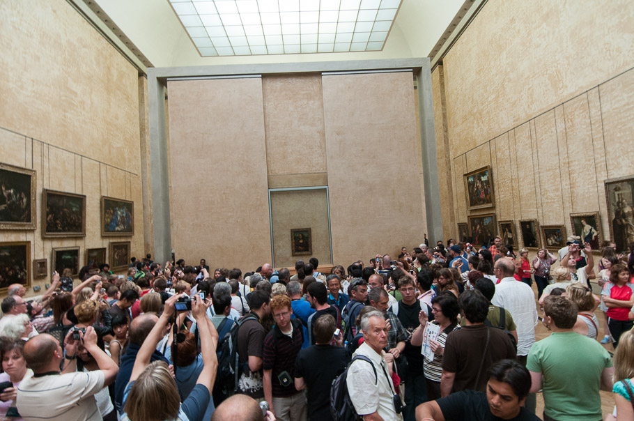 Mona Lisa fever! Crowd in front of a tiny Mona Lisa painting protected behind glass